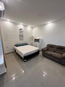 um quarto com uma cama e um sofá em Pontal do Atalaia 28 em Arraial do Cabo