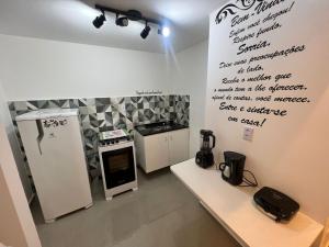 uma pequena cozinha com uma placa na parede em Pontal do Atalaia 28 em Arraial do Cabo