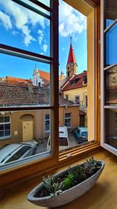 a window with a view of a city through it at Medieval Super Studio in Vilnius