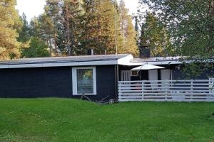 una casa negra con una valla blanca en un patio en Magic lapland villa, en Rovaniemi