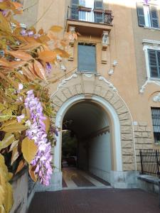 un ingresso a un edificio con arco e fiori viola di Albergo Enrica a Roma