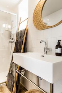 ein Bad mit einem Waschbecken und einem Spiegel in der Unterkunft Mer nature, appartement spacieux by Les Filles du Bord de Mer, petite terrasse vue mer in Port-en-Bessin-Huppain