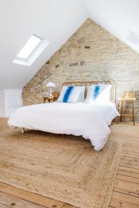 ein Schlafzimmer mit einem großen Bett und einer Steinmauer in der Unterkunft Mer nature, appartement spacieux by Les Filles du Bord de Mer, petite terrasse vue mer in Port-en-Bessin-Huppain