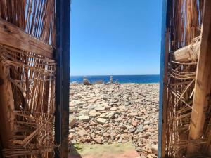 a view of a rocky beach from a building at Cosmos Camp in Dahab