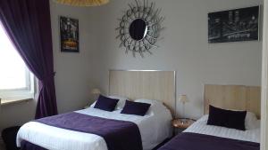 a bedroom with two beds and a mirror on the wall at Au Moulin d'Or in Lille