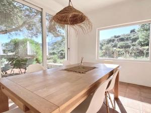 une salle à manger avec une table en bois et une grande fenêtre dans l'établissement CORTIJO JUNTO AL MAR EN PARQUE NATURAL, à Presillas Bajas
