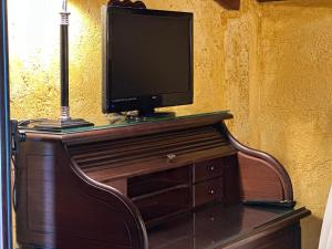a television sitting on top of a wooden dresser at Casa Rural Ermita Santa Maria de la Sierra in Arroyo Frio