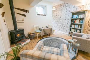 a living room with a couch and a stove at Cae Mab Dafydd in Llanfairfechan