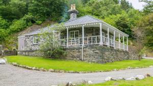 ein großes Steinhaus mit einem großen Vorgarten in der Unterkunft Cae Mab Dafydd in Llanfairfechan