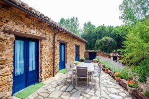 un edificio de piedra con una mesa y sillas en un patio en CASA COLOMBA, en Santa Colomba de Somoza