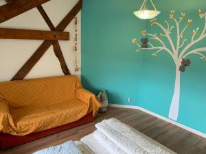 ein Schlafzimmer mit einem Bett und einem Baum an der Wand in der Unterkunft Maison de famille au vert classée 3 étoiles in Les Andelys