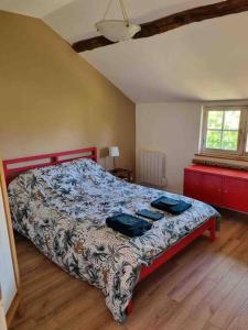 a bedroom with a bed with a comforter and a window at Maison de famille à la campagne classée 3 étoiles in Les Andelys
