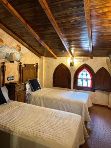a bedroom with two beds and a stained glass window at Casa Rural Ermita Santa Maria de la Sierra in Arroyo Frio