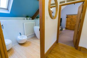 a bathroom with a toilet and a sink and a mirror at Tal Y Bont Uchaf Courtyard in Bangor +86 photos