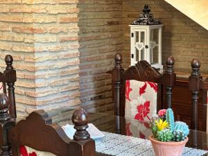 a table with a chair and a table with a lamp at Casa Rural Ermita Santa Maria de la Sierra in Arroyo Frio