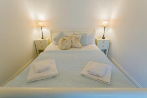 1 dormitorio con 1 cama con 2 toallas en Tal Y Bont Uchaf Cottage, en Bangor