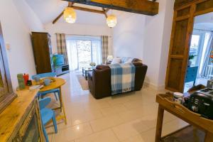 a living room with a couch and a table at Tal Y Bont Uchaf Cottage in Bangor