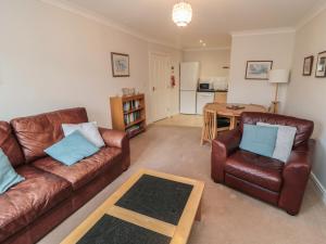 a living room with two leather couches and a table at Quayside Haven in Whitby