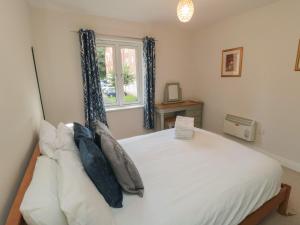 a bedroom with a white bed with a window at Quayside Haven in Whitby