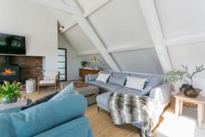 a living room with blue couches and a fireplace at The Old Abbey in Trearddur