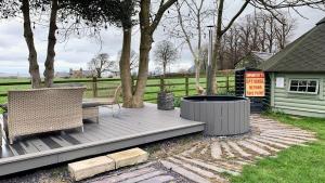 a wooden deck with two chairs and a fire pit at Tal Y Bont Uchaf Stables in Bangor