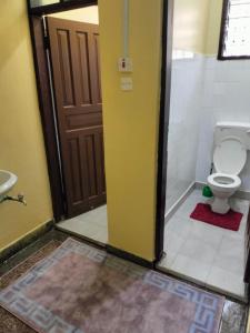 een badkamer met een toilet en een deur open bij Asya Homes in Mombasa