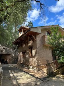 アロヨ・フリオにあるCasa Rural Ermita Santa Maria de la Sierraのバルコニー付きの古いレンガ造りの建物