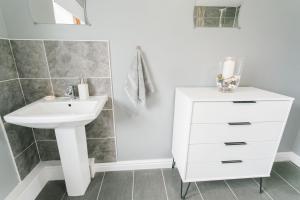 a bathroom with a sink and a white cabinet at Tan y Bryn Bach in Llanllechid +33 photos