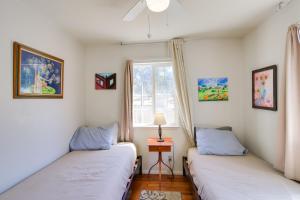 2 camas en una habitación con ventana en Eclectic Oroville Cottage with Charcoal Grill!, en Oroville