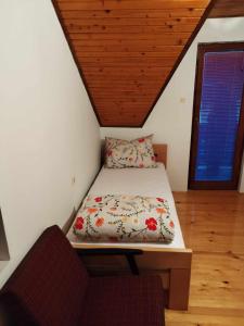 Łóżko w pokoju z drewnianym sufitem w obiekcie Prenoćište Rubin 