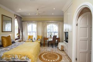 a bedroom with a bed and a dining room at La Loggia Bed and Breakfast in Durban