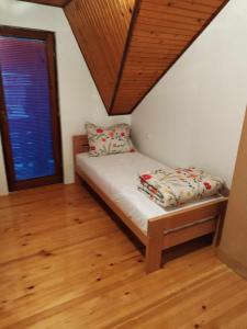 Habitación pequeña con cama y ventana en Prenoćište Rubin 