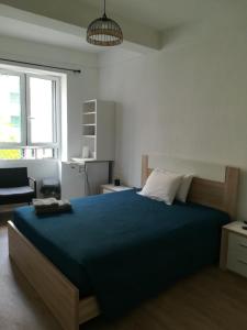 a bedroom with a large bed with a blue blanket at Cc39 -Q1 in Funchal