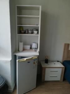 a small kitchen with a refrigerator and a shelf at Cc39 -Q1 in Funchal
