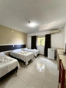 Habitación de hotel con 2 camas y ventana en Hotel Castelo Branco en Foz de Iguazú