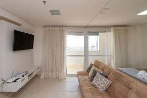 uma sala de estar com um sofá e uma grande janela em Brookfield Tower - BFT em Goiânia