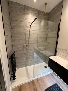 um chuveiro com uma porta de vidro na casa de banho em Hamlet Court Apartments 1A em Southend-on-Sea