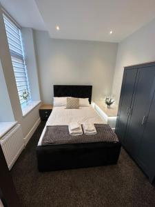 a bedroom with a bed with two towels on it at Hamlet Court Apartments 1A in Southend-on-Sea