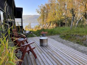 een houten terras met een bank en een tafel bij Håkøya Lodge in Tromsø