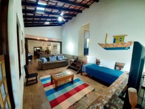 a living room with a blue bed and a couch at Casa da Ilha Paraty Entre a mata atlântica e o mar in Paraty