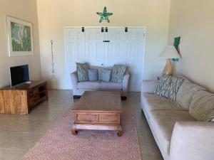 ein Wohnzimmer mit einem Sofa und einem Couchtisch in der Unterkunft Villa Belvedere - 5 minutes walk to the Beach in Dickenson Bay