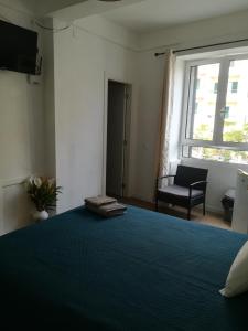 a bedroom with a bed and a window and a chair at Cc39 -Q1 in Funchal