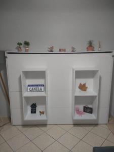 Una pared blanca con dos estanterías en una habitación en Apartamento a 3min do centro Canela, en Canela 3 fotos más