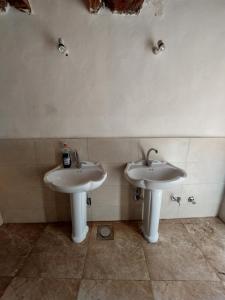 a bathroom with two white sinks in a room at Forest Camp Siwa - كامب الغابة in Siwa