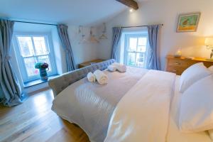 ein Schlafzimmer mit einem großen weißen Bett mit Handtüchern darauf in der Unterkunft 10 Bunkers Hill in Beaumaris