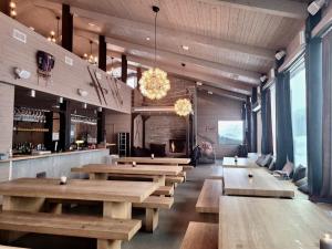 um restaurante com mesas de madeira e um bar em Gausta View Lodge em Gaustablikk