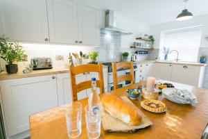 a kitchen with a table with a loaf of bread on it at 45 Bryn Lane in Beaumaris