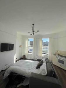 1 dormitorio con 1 cama grande y 2 ventanas en Forte circle, luxury apartments en South Norwood
