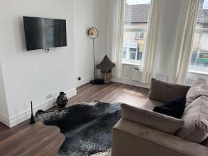 a living room with a couch and a flat screen tv at Forte circle, luxury apartments in South Norwood
