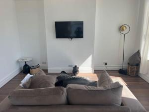 a living room with a couch and a flat screen tv at Forte circle, luxury apartments in South Norwood